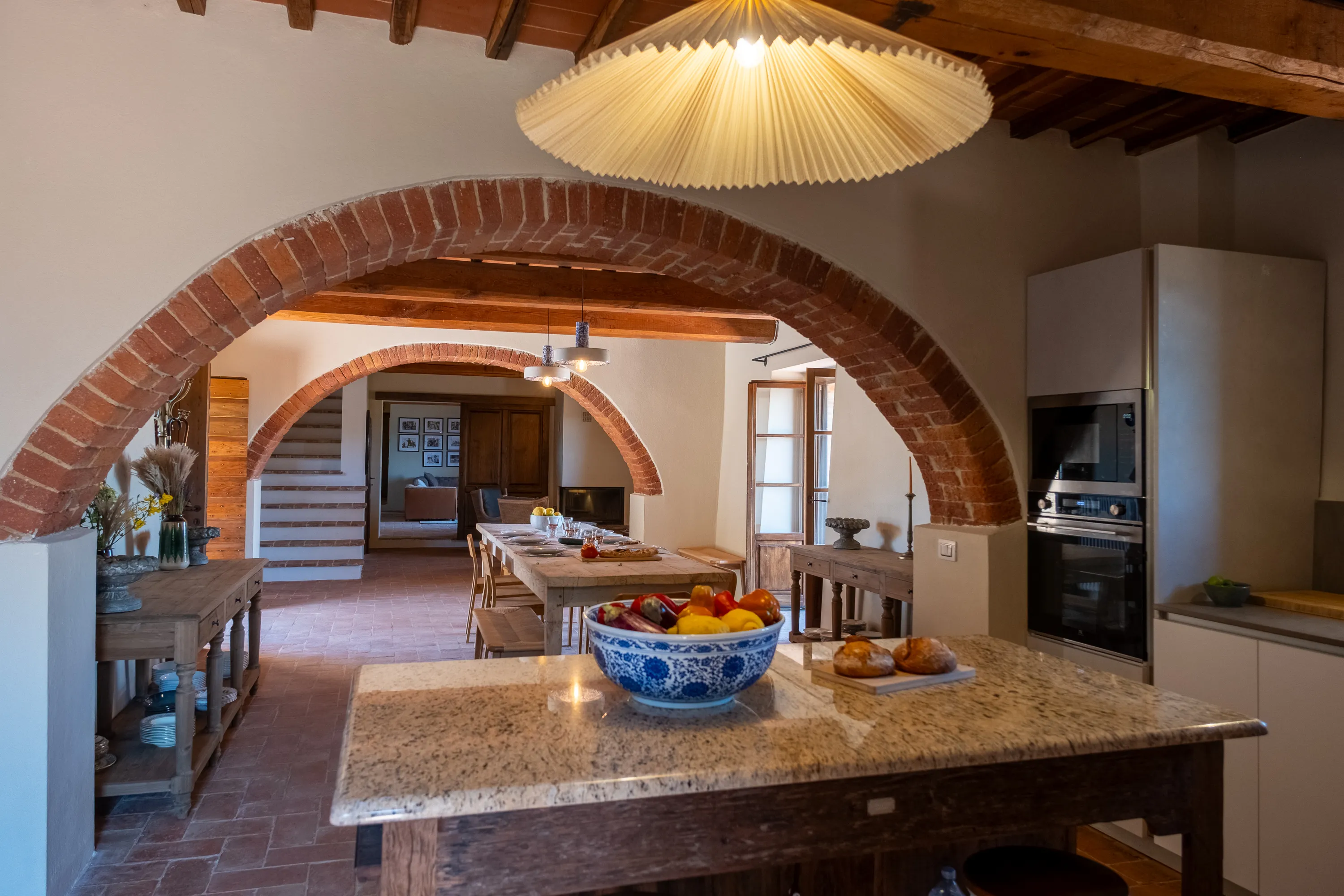 Cucina sotto l'arco di mattoni con isola centrale