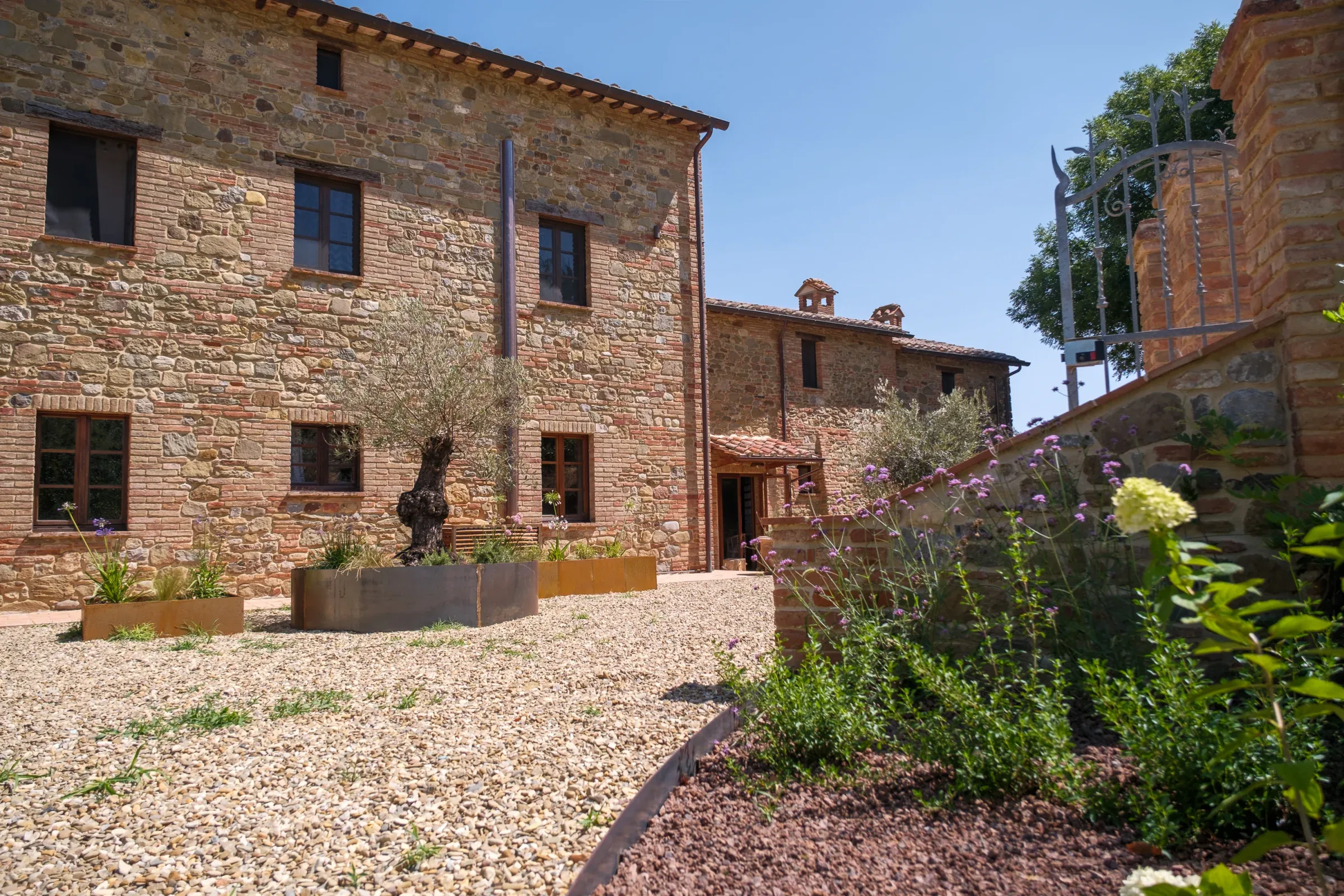 Stone façade bordered by flowers in the courtyard