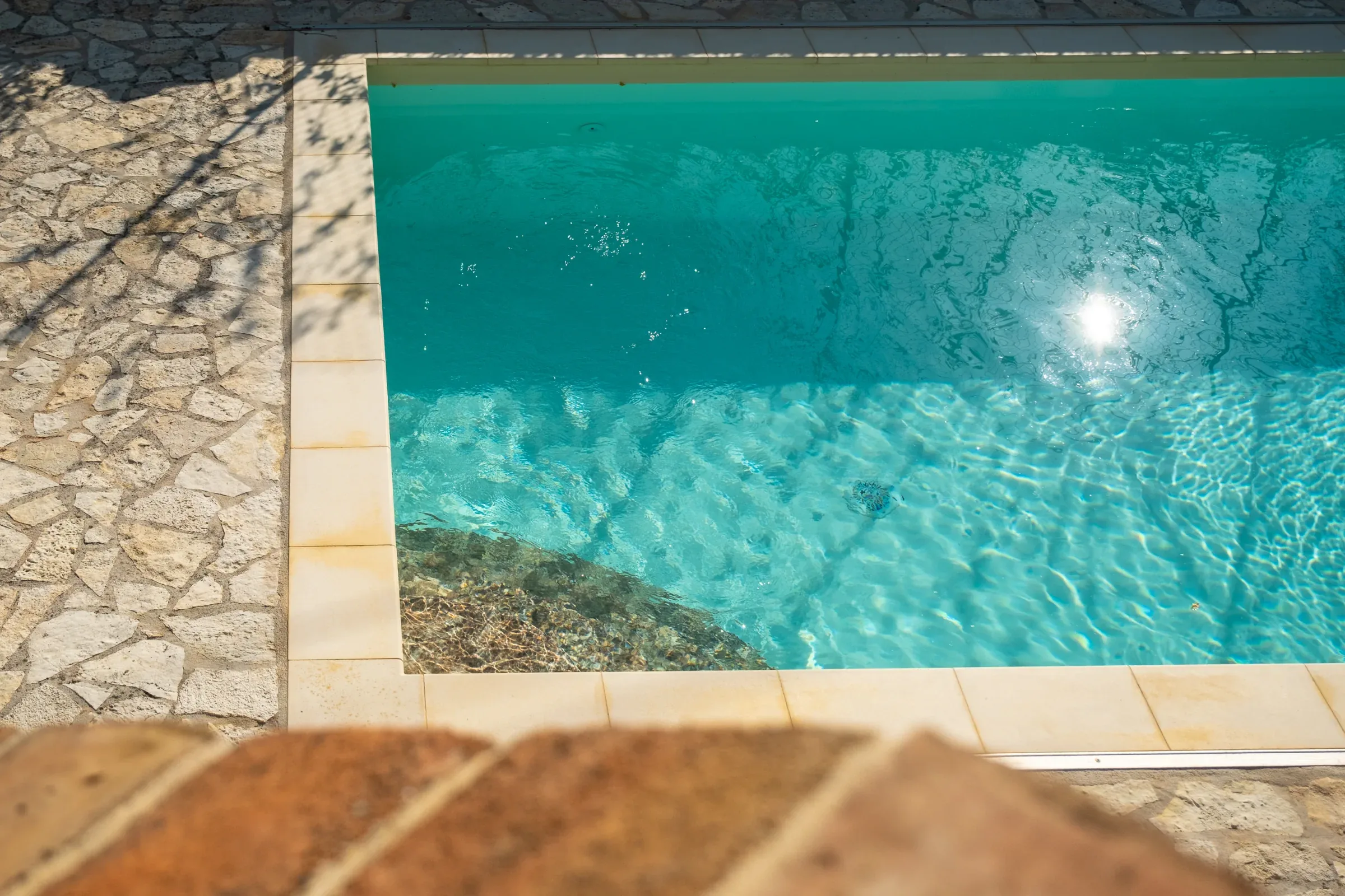 Corner of the pool with sunlight on the water