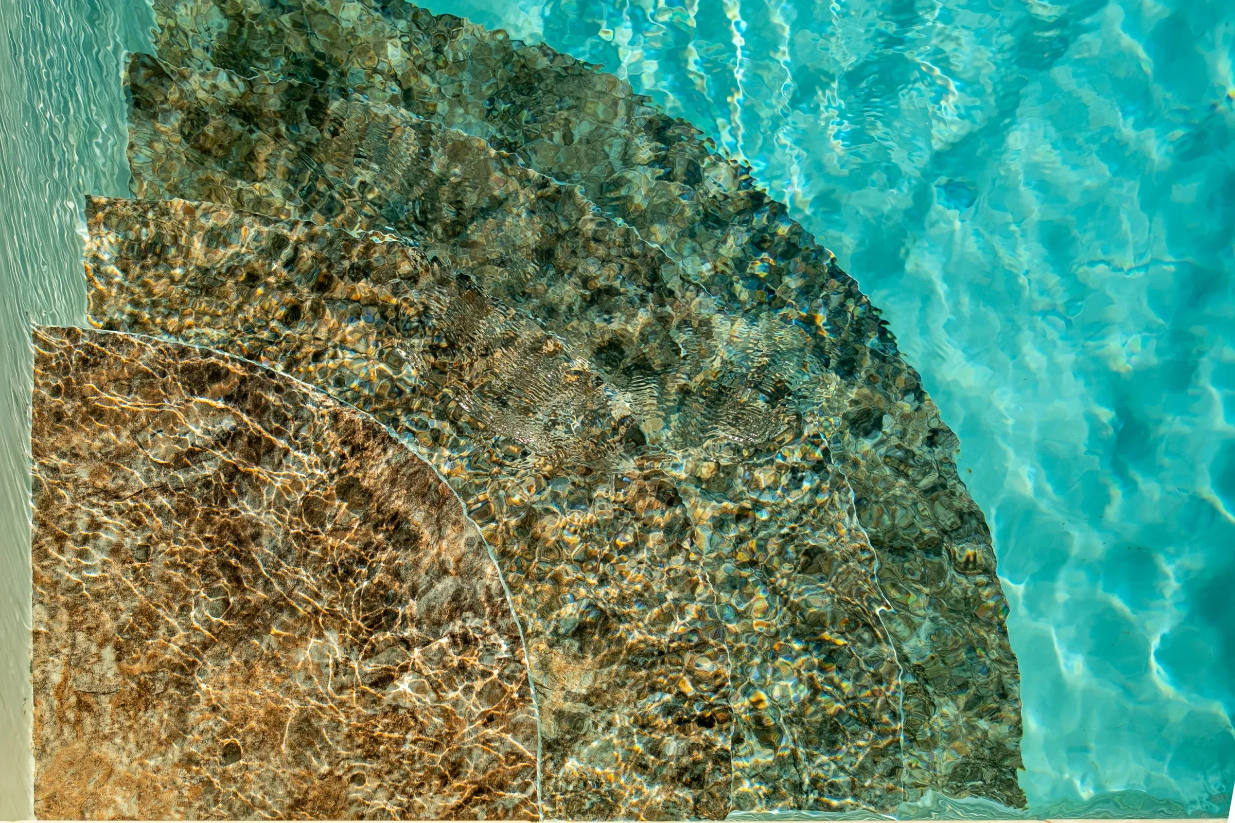 Marches en pierre visibles sous l’eau de la piscine
