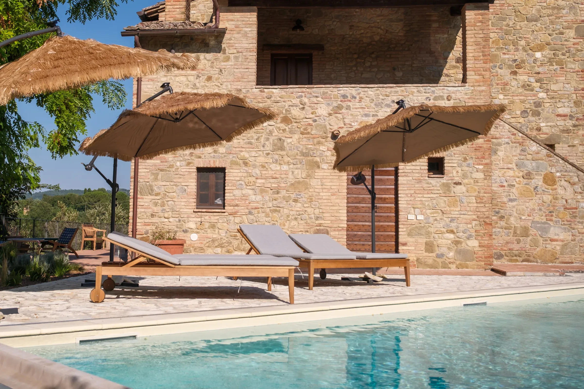 Sun loungers by the pool facing the villa