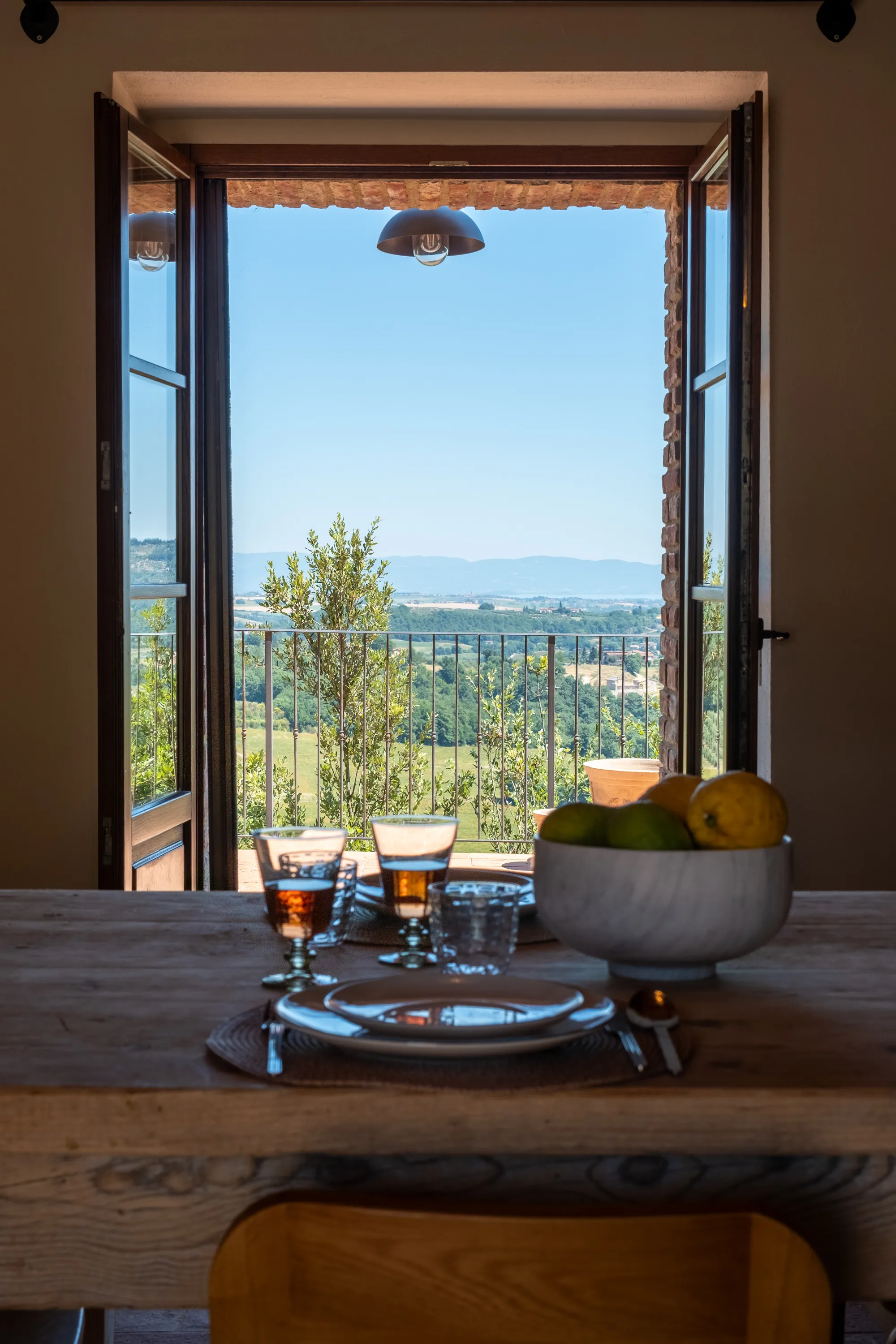 Table dressée devant la porte-fenêtre ouverte sur la vallée