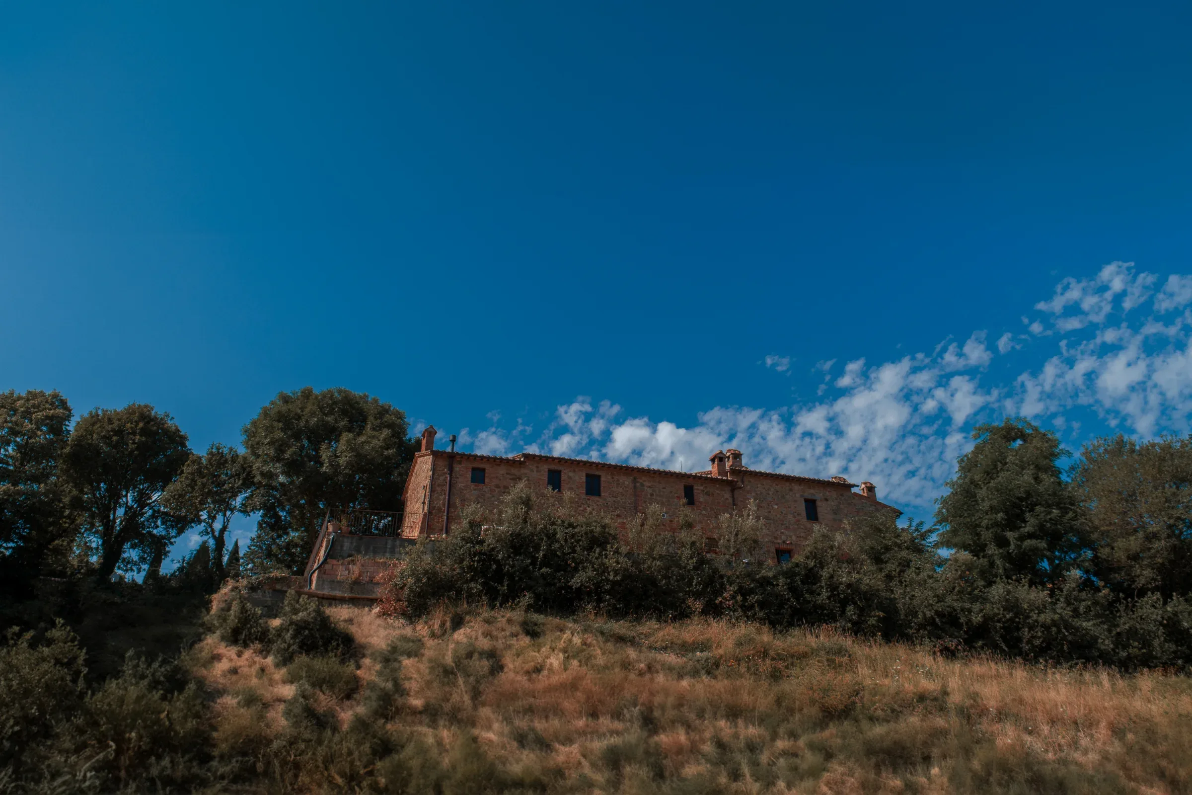 Stone villa on the hillside beneath a blue sky