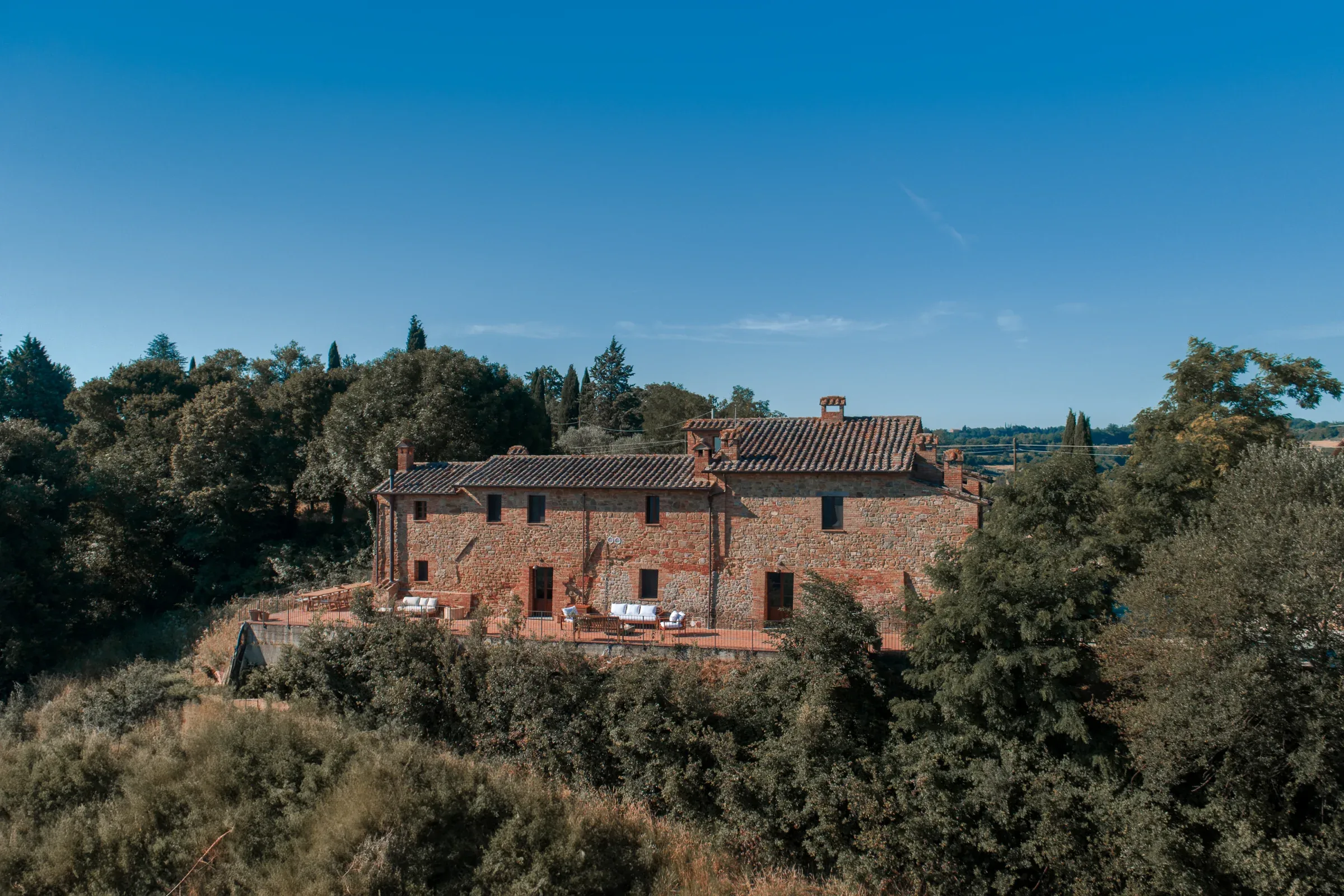 Facciata della villa circondata da colline e querce