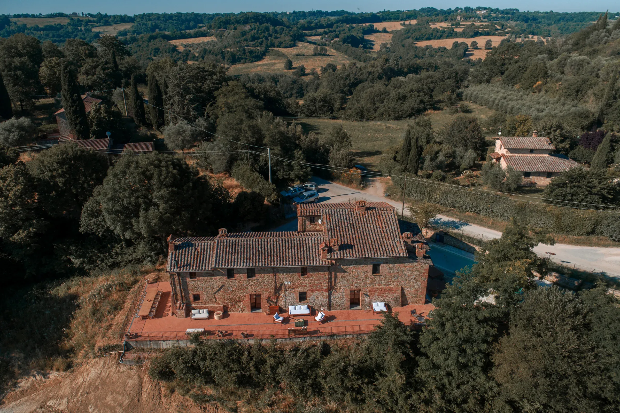 Vista aerea obliqua della villa, terrazza e piscina
